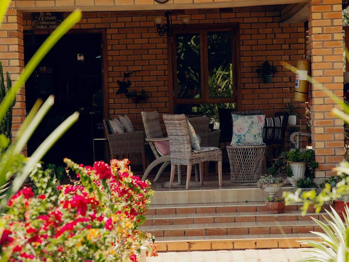 The veranda entrance with bougainvillea and cane chairs